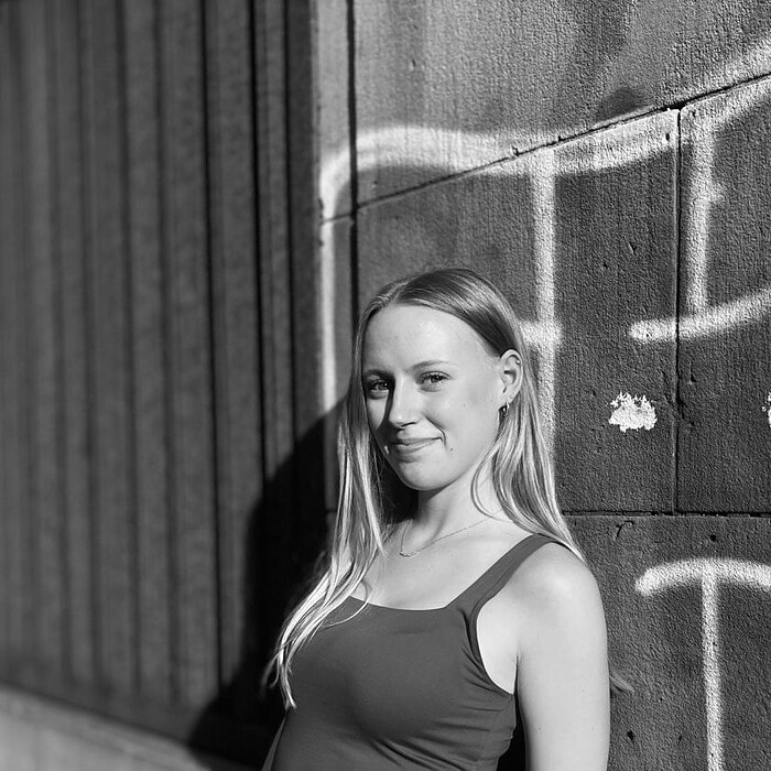 Frau beim Tanzen vor einer Graffiti-Wand in Wuppertal.